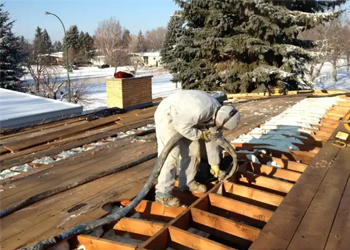 Sunny South Inc employee spraying foam insulation into roof